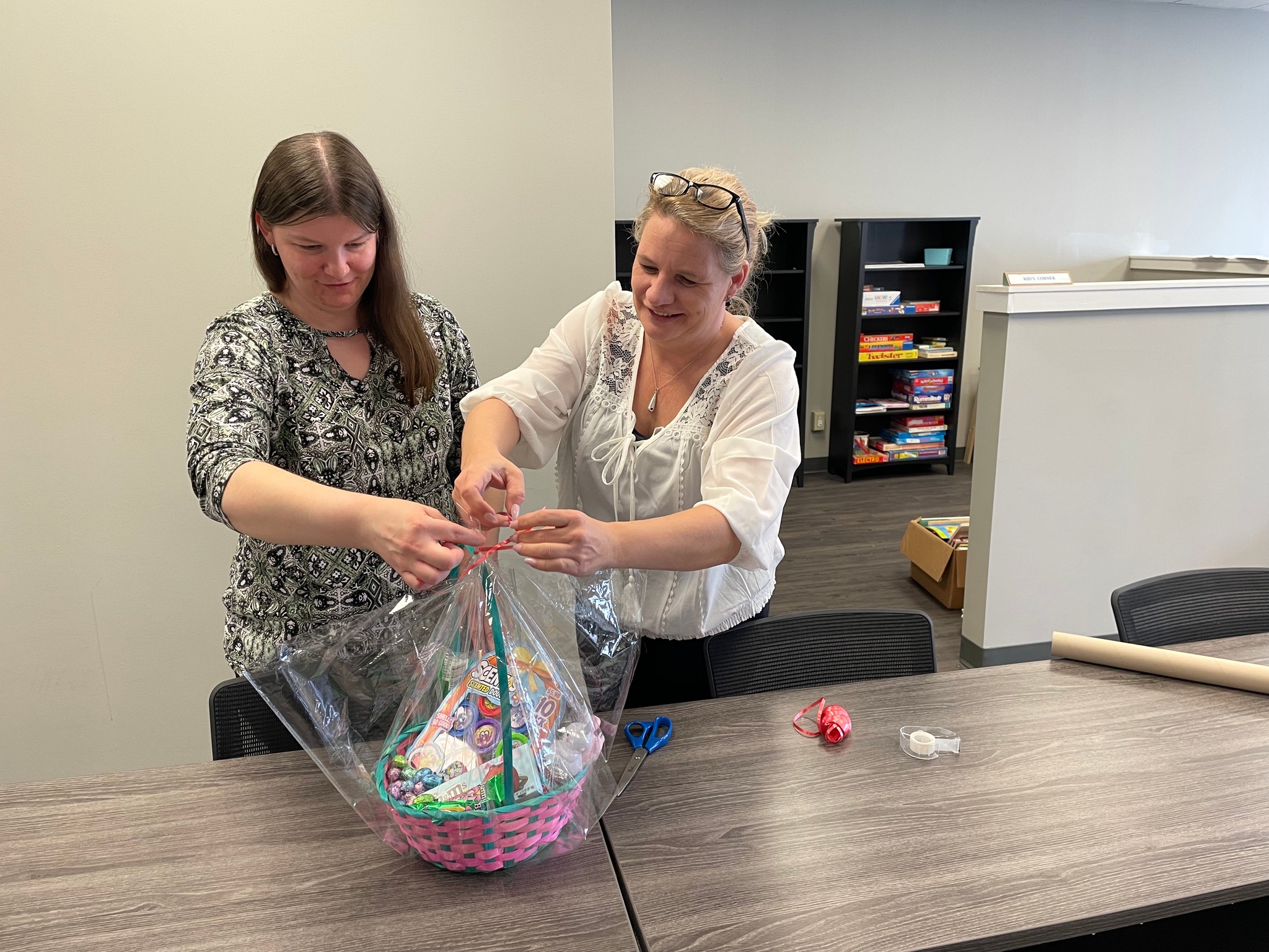 Just Neighbors volunteers making a gift basket for guests.